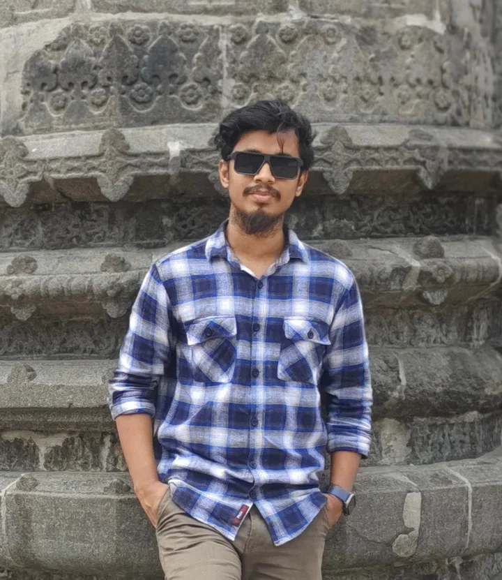 Salam Sheikh standing in front of a stone building